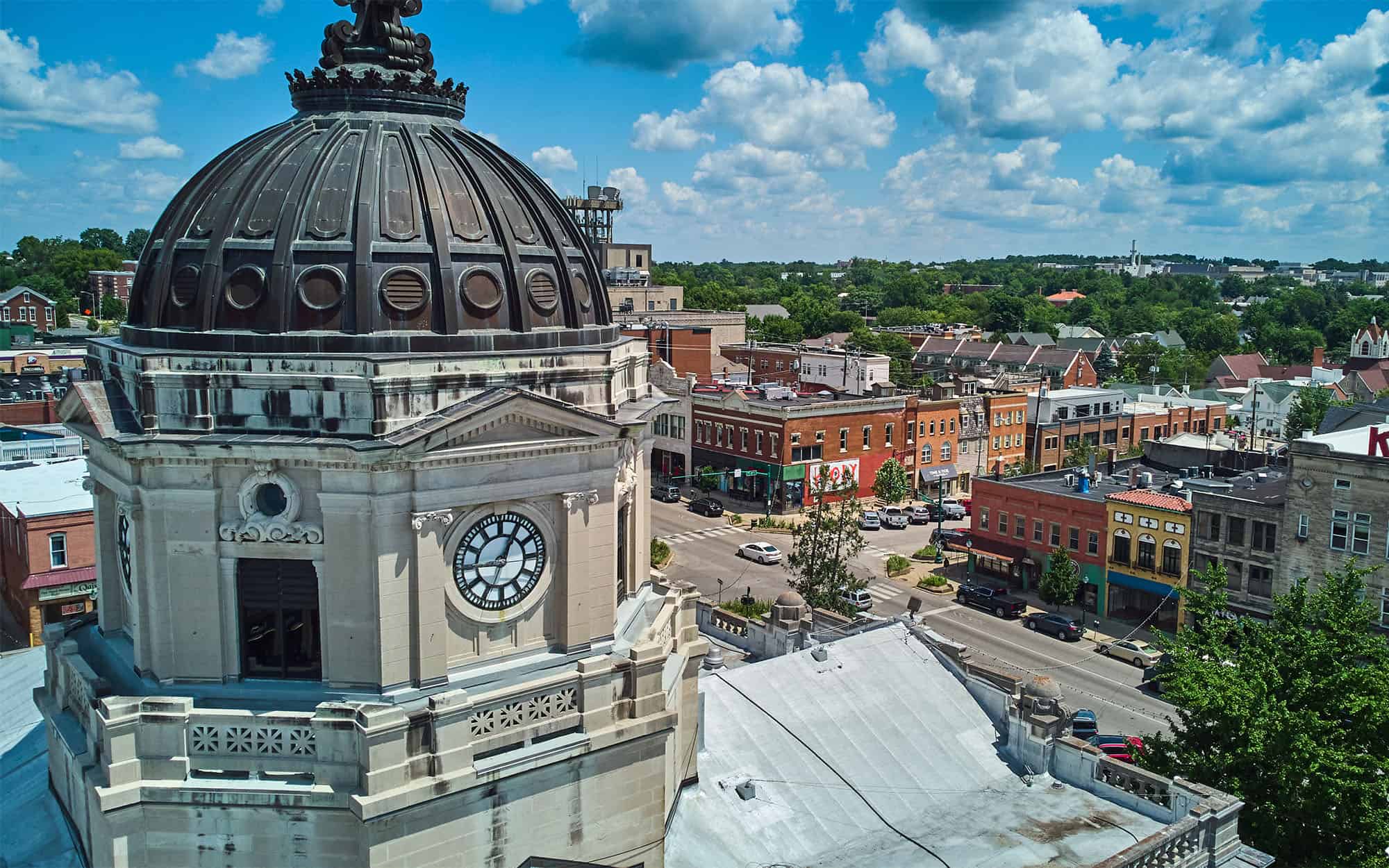 Up close to top of Bloomington Indiana courthouse clock with downtown in background